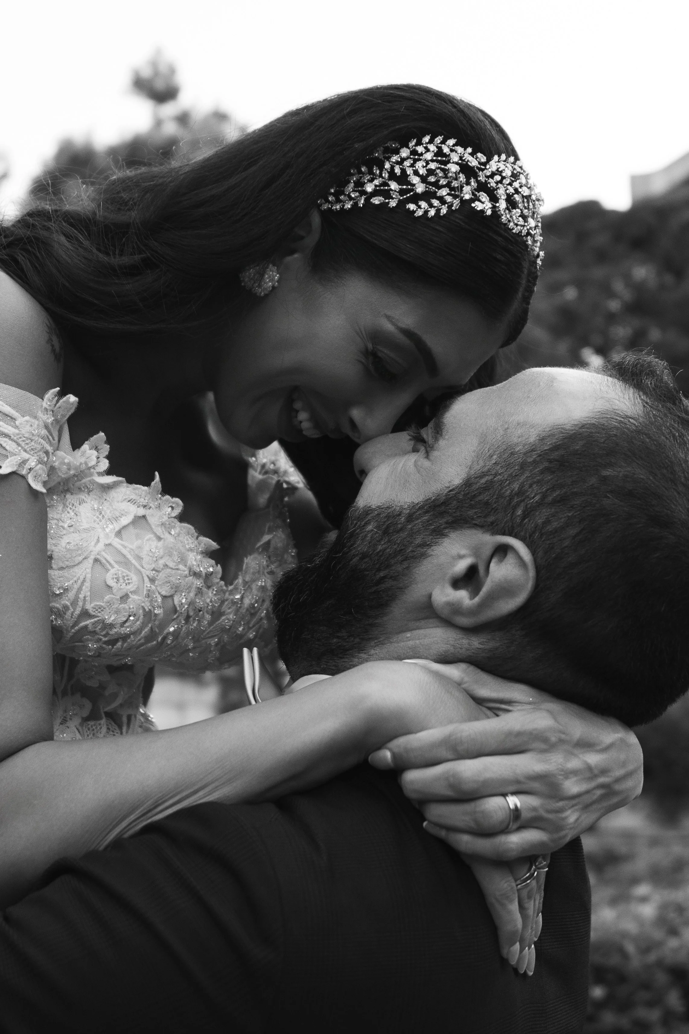 Una pareja se abraza y se sonríe con la frente tocándose, en una foto en blanco y negro.