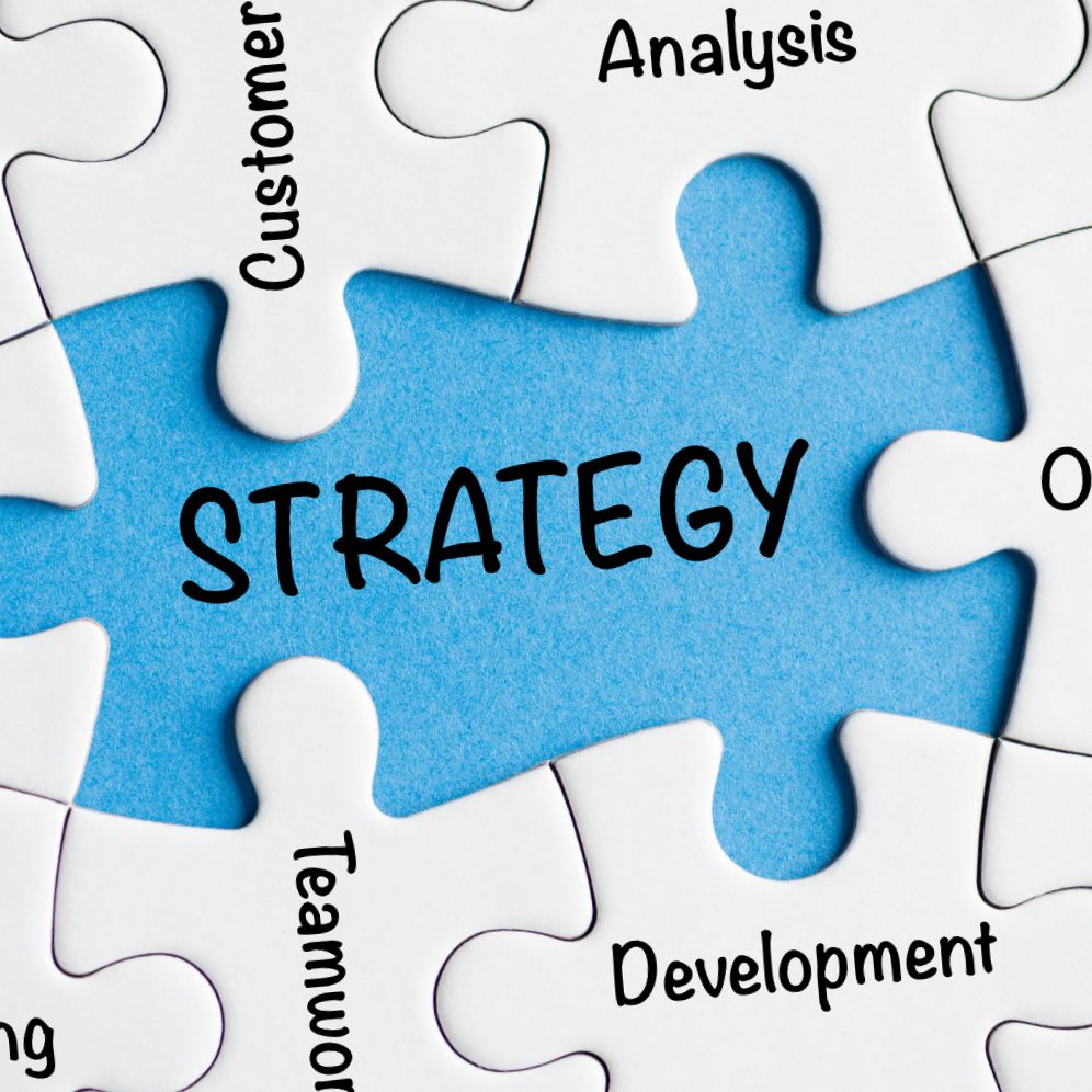 A puzzle with the word "STRATEGY" in the center surrounded by pieces labeled "Customer," "Analysis," "Development," and "Teamwork."