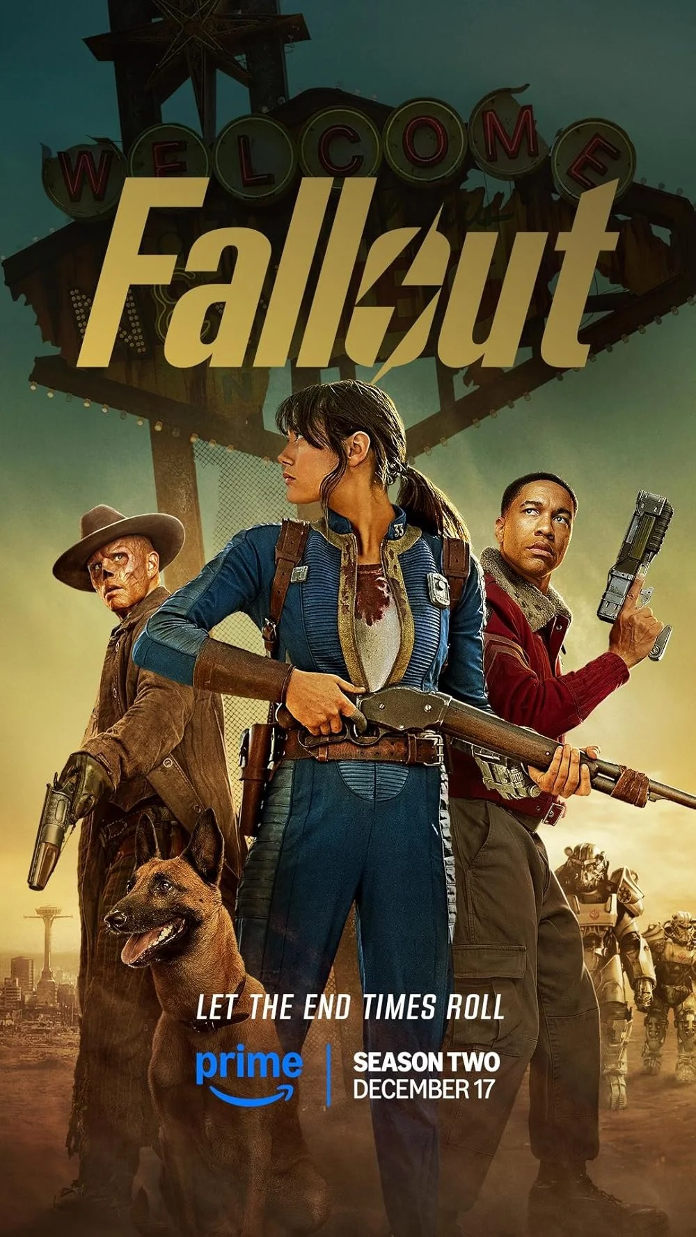 Promotional poster for season two of the TV series 'Fallout.' The poster features three characters standing in front of a dilapidated amusement park with a sign that says 'Welcome.' The characters include a woman in a blue jumpsuit holding a rifle, a