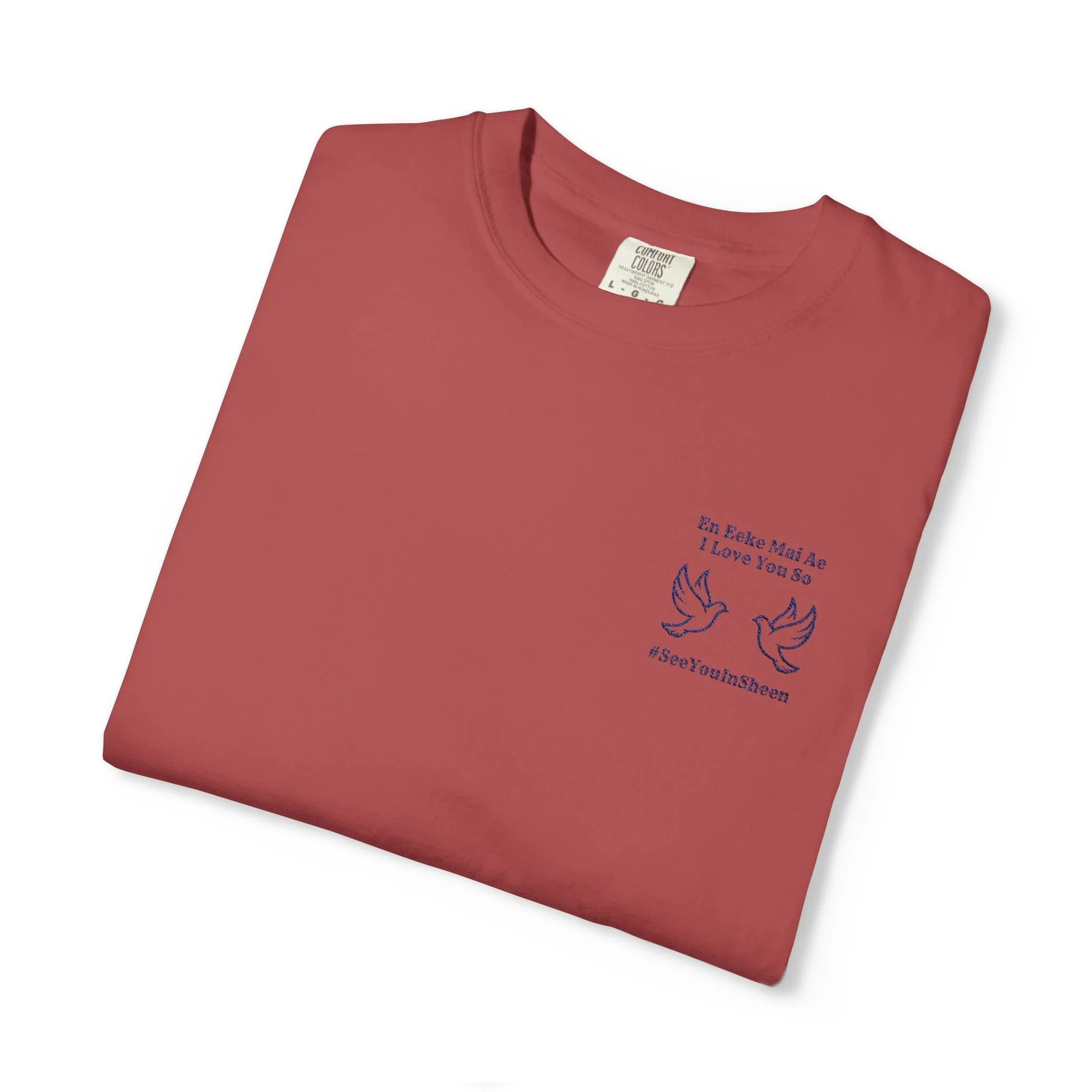 A folded red t-shirt with a white tag at the neckline and blue text and graphic on the front.