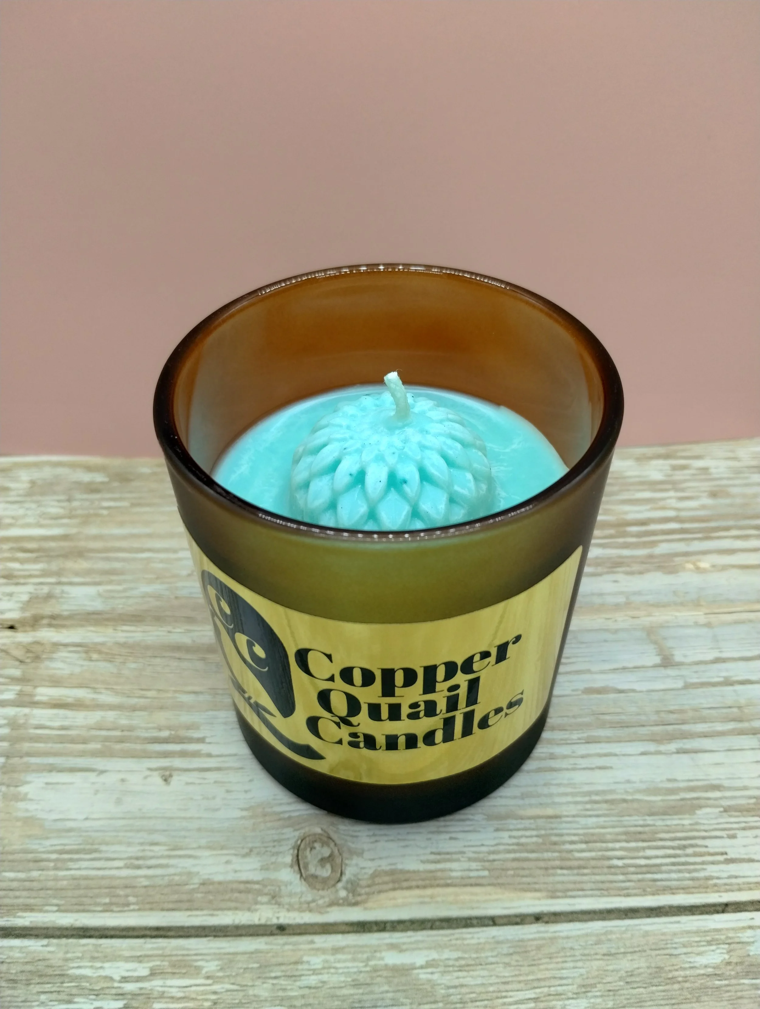 green candle in a frosted brown jar
