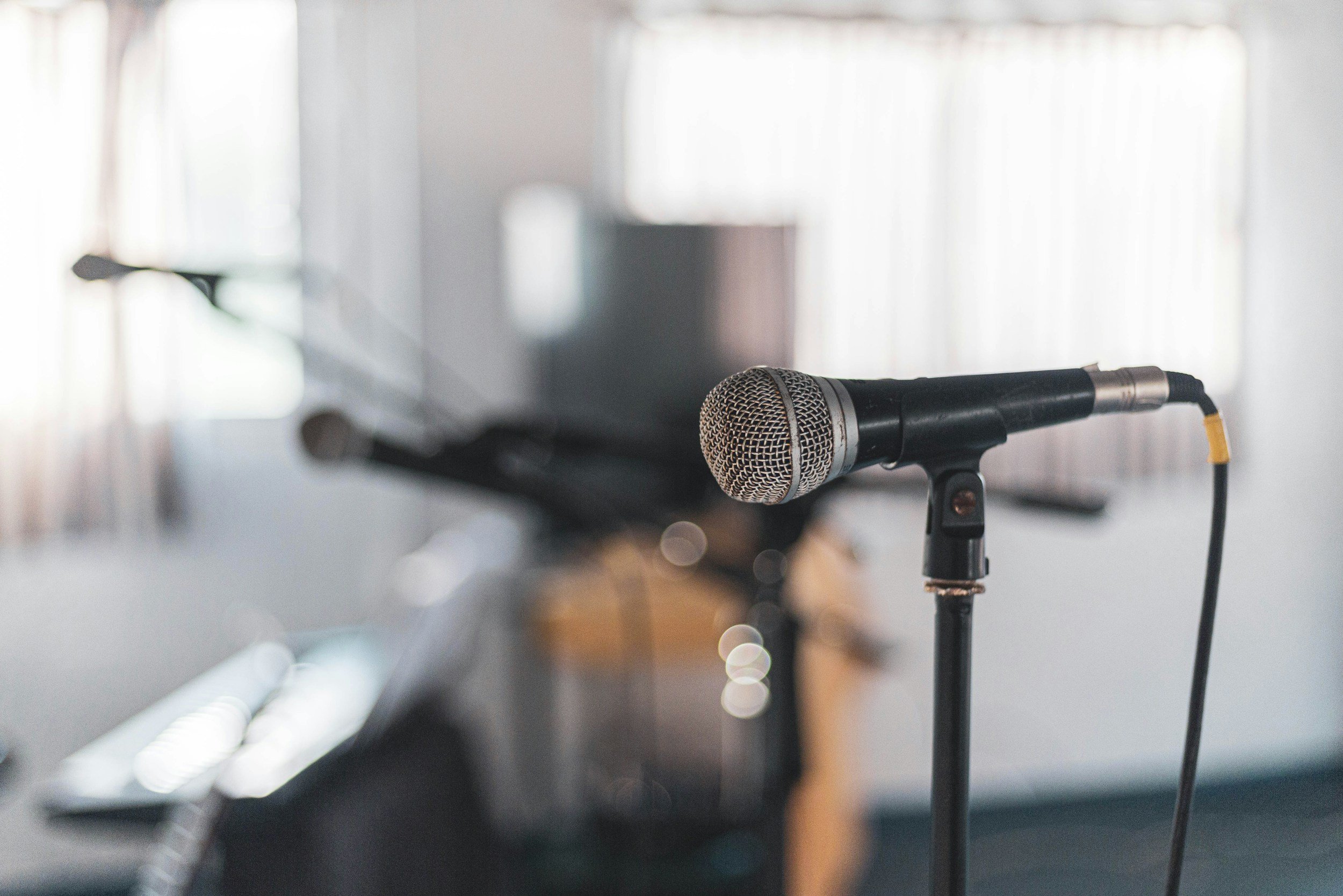 Microphones in a studio with piano in the background