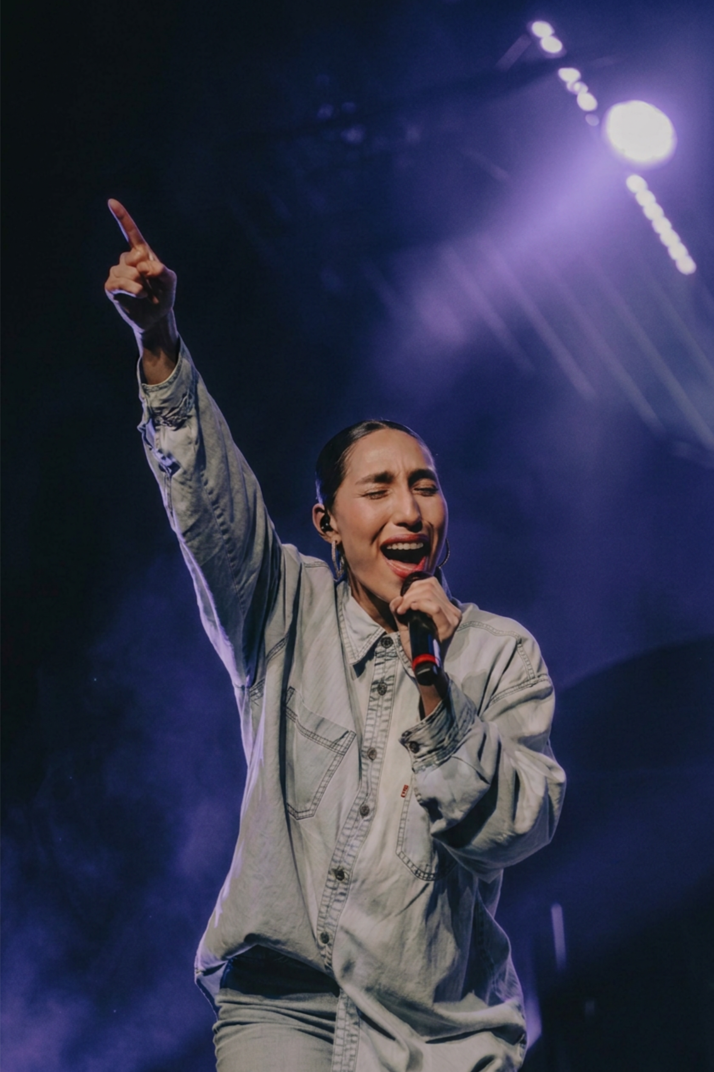 Female vocalist performing live on stage with microphone