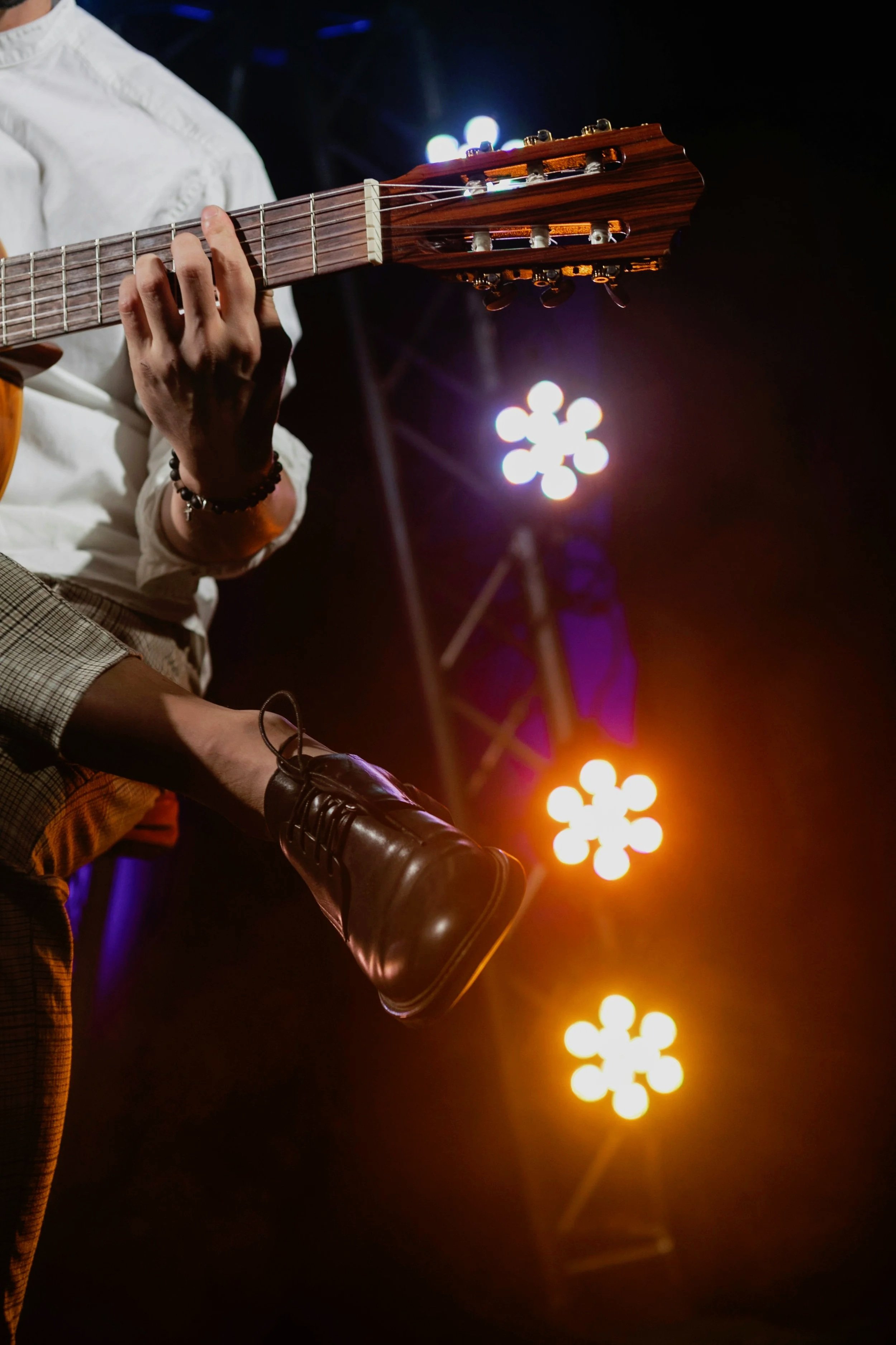 Singer-songwriter performing with acoustic guitar on stage