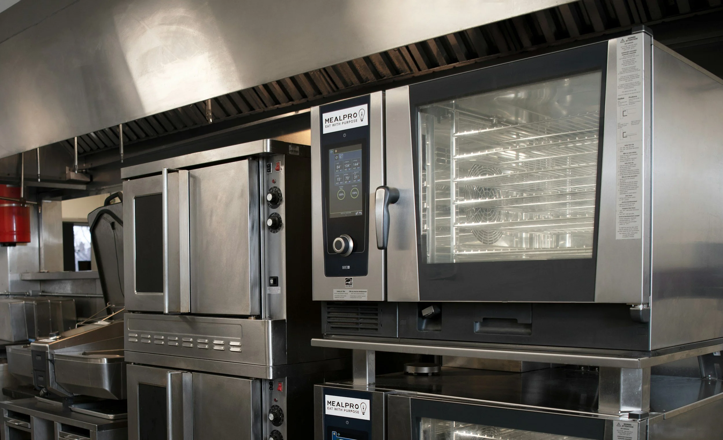 Commercial kitchen oven with digital controls and glass door, labeled MEALPRO, stainless steel construction.