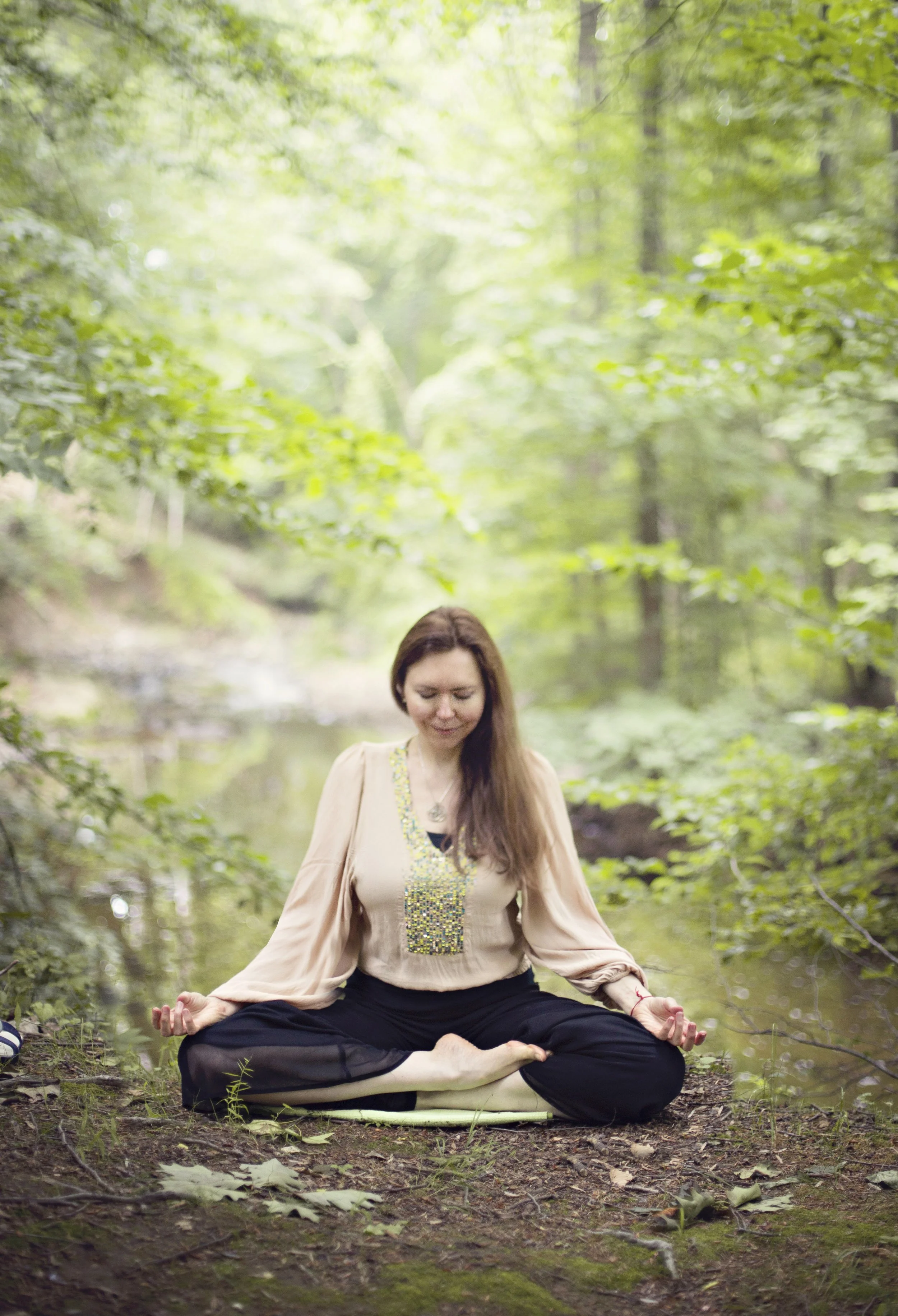 Dr. Lienna Wilson meditating cross-legged in a forest, practicing slow, calm breathing to support the vagus nerve