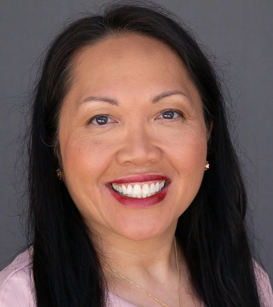 Headshot of Dr. Carina Hopen, MD, smiling against a grey studio background