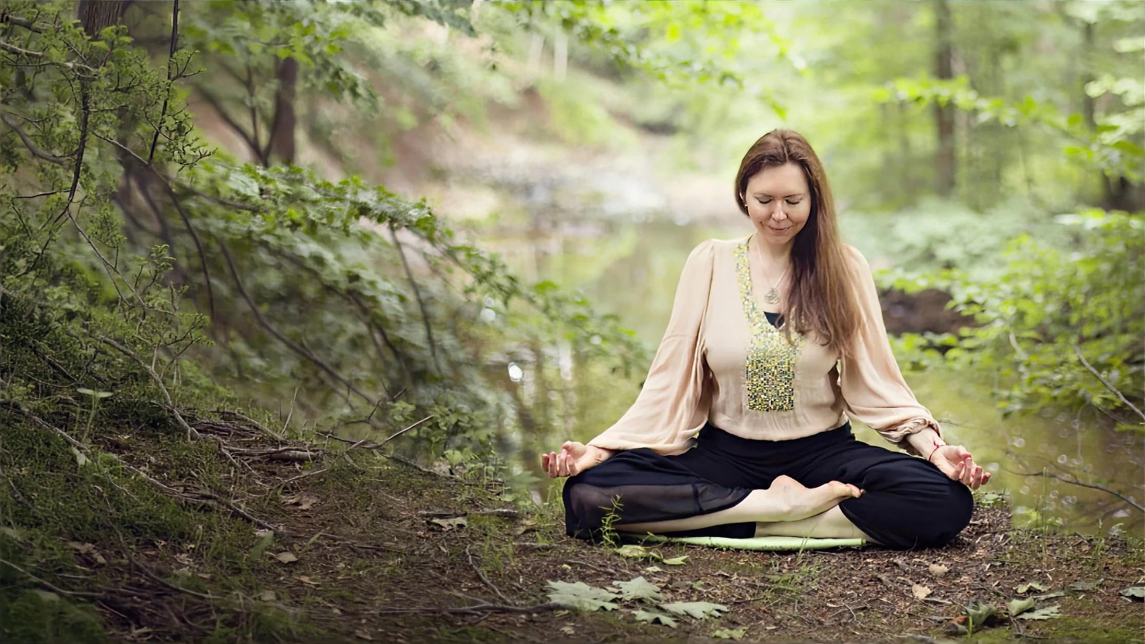 Dr. Lienna Wilson, a licensed psychologist, meditating outdoors in a green forest setting.