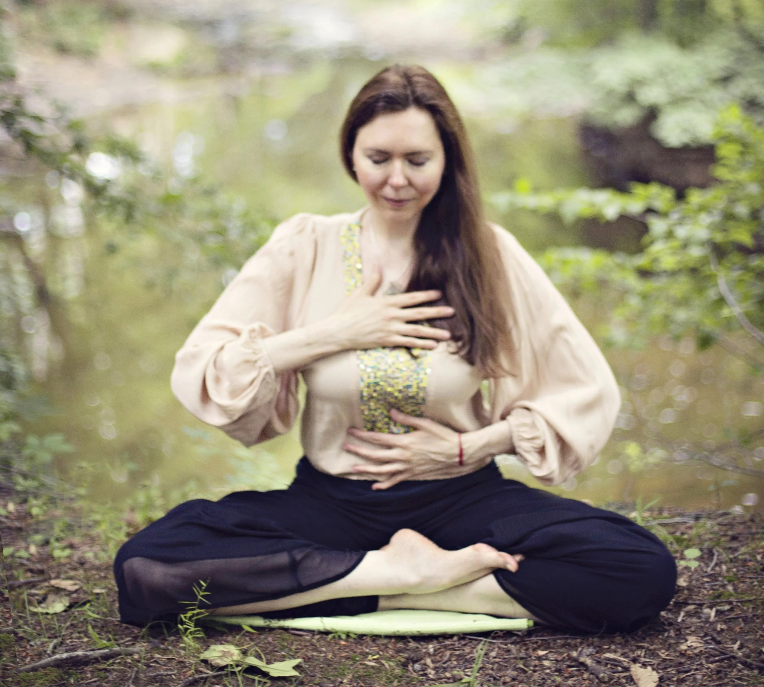 Dr. Lienna Wilson demonstrating diaphragmatic breathing outdoors, one hand on the chest and one on the abdomen