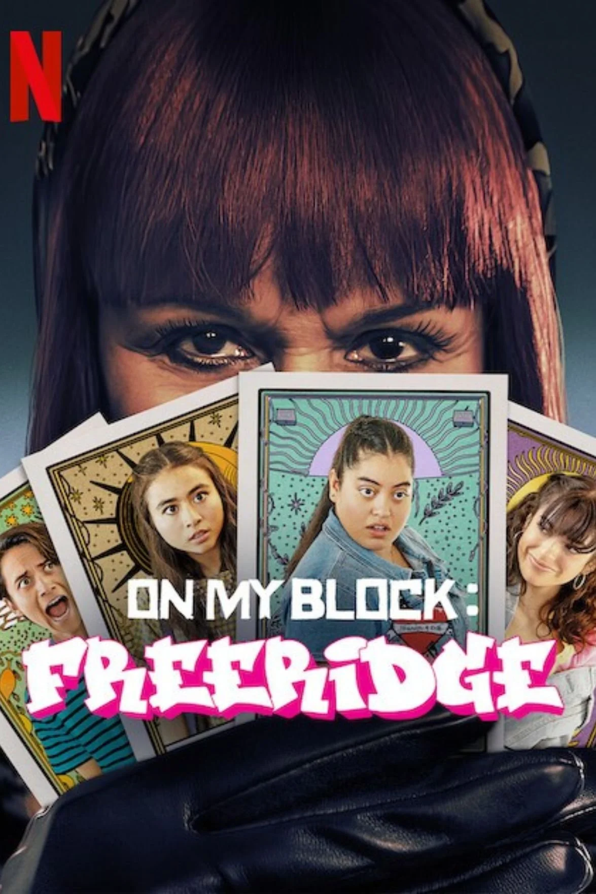 A person holding magazines featuring characters from the TV show 'Freaky Friday,' with a woman with dark red hair and bangs in the background. The magazines display various characters, including a girl with braided hair, a woman with curly hair, and others, surrounded by colorful illustrations and text.