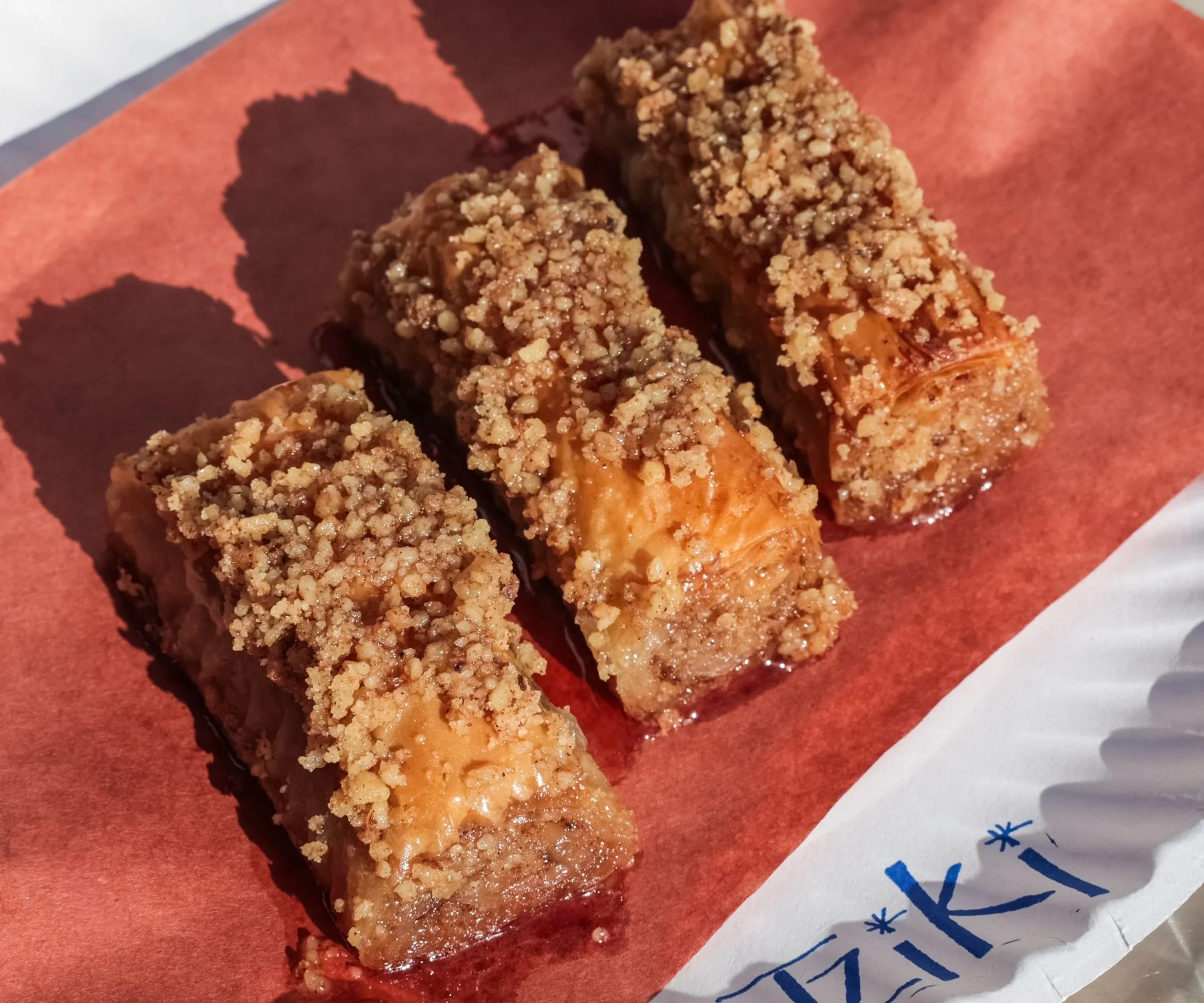 Traditional saragli Greek baklava rolls with crushed walnuts, cinnamon, and honey syrup at Tziki, authentic Greek dessert in Chelsea Manhattan NYC