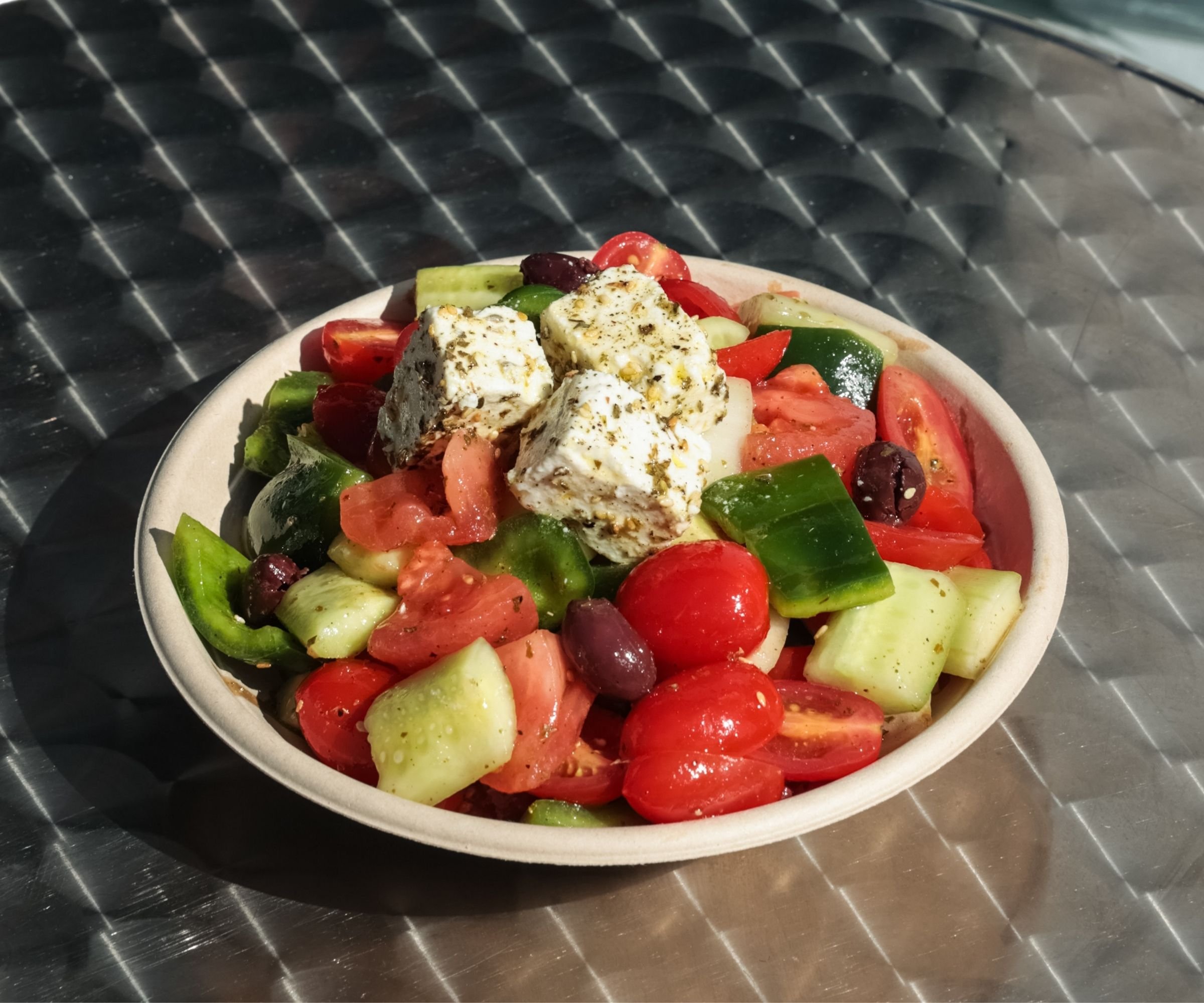 Horiatiki Greek salad with tomato, cucumber, Kalamata olives and blocks of PDO feta — Tziki