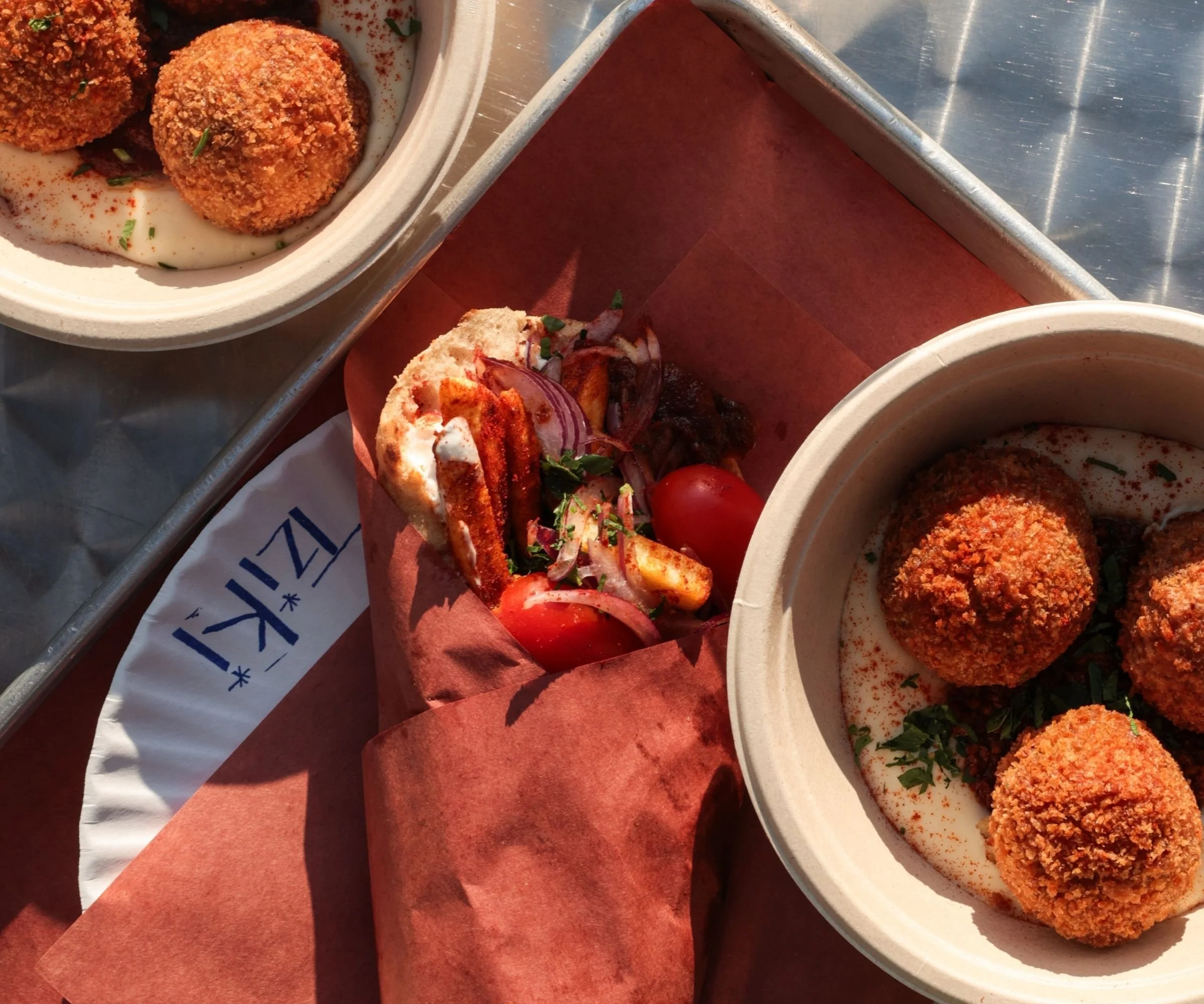 Spetzofai — Greek sausage in tomato and pepper saltsa with grilled halloumi in a Cypriot pocket pita — Tziki