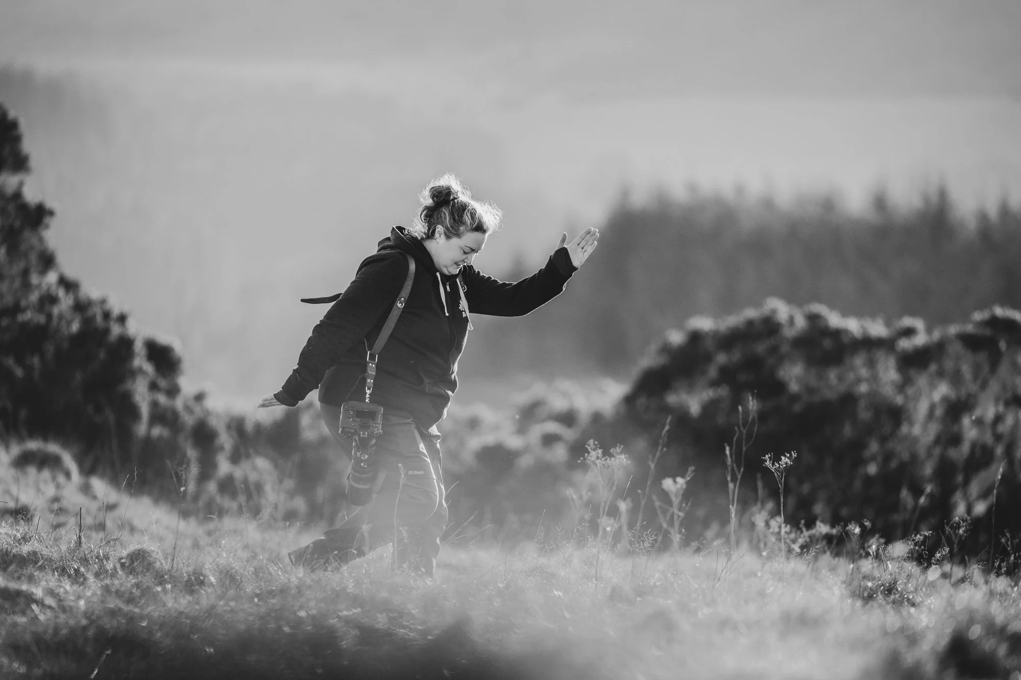 A black and white image of Laura pretending to be a horse in Scotland on the hills to demonstrate distances