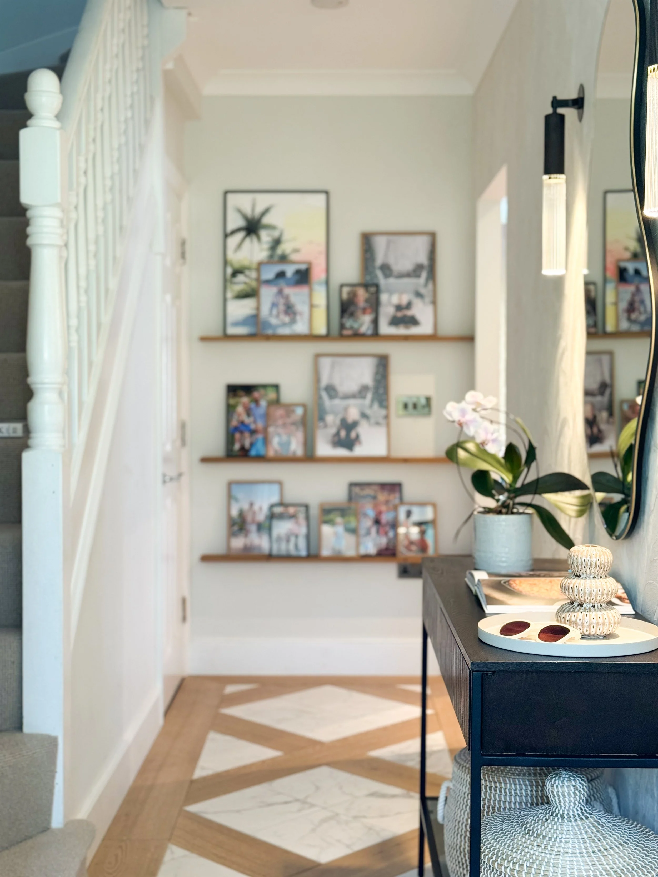 The first thing you see when you open the front door sets the tone for everything that follows. A bespoke inlaid floor in oak and marble announces that this is a home where the detail has been thought through. The gallery shelving beyond keeps the en