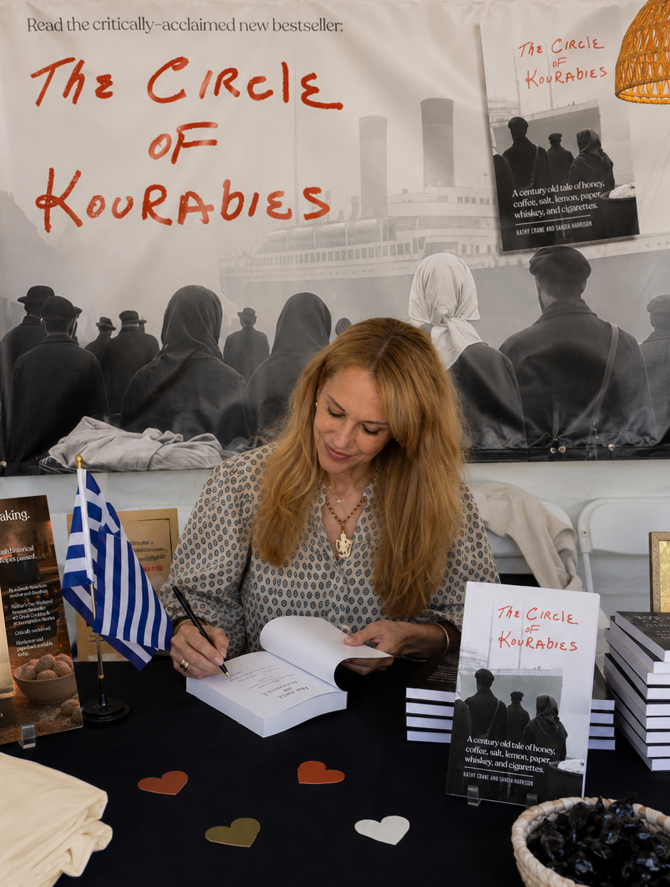 The author, Sandia Harrison, signing a copy of The Circle of Kourabies at a Greek Heritage Festival