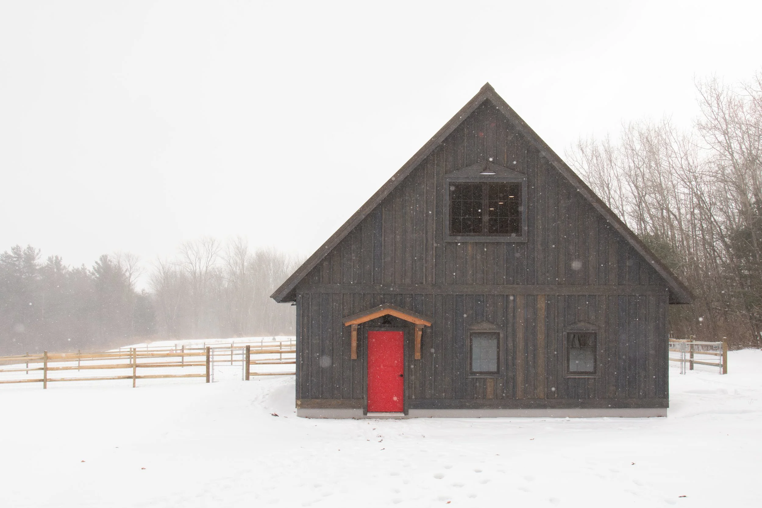 a custom barn with rustic hemlock and a red accent entry door