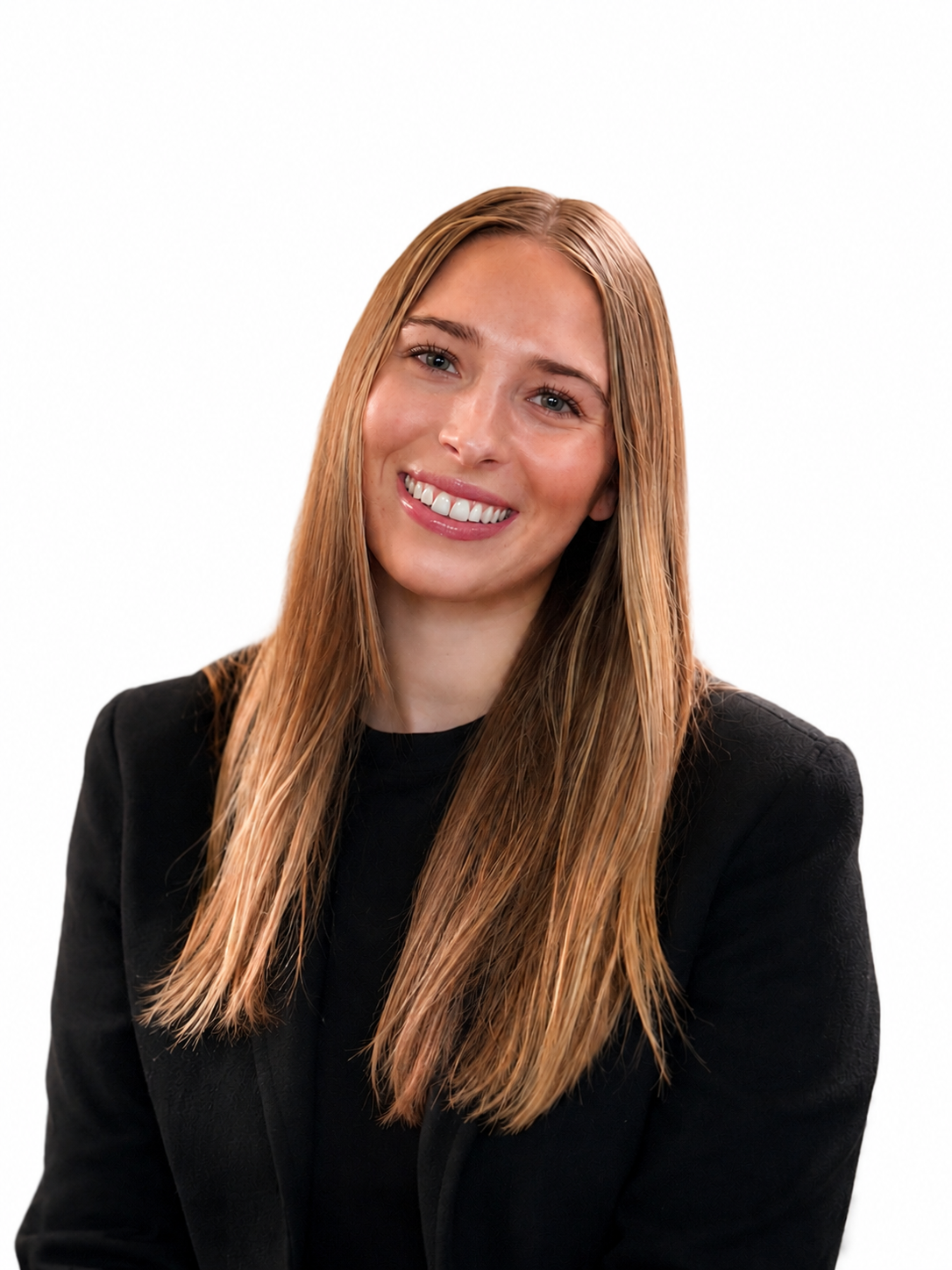 A woman with long, straight, auburn hair, smiling with teeth visible, wearing a black blazer against a plain white background.