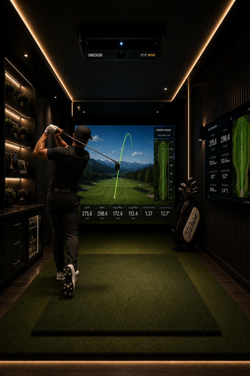 A golfer is practicing indoors using a golf simulator, with a view of a virtual golf course displayed on screens showing stats and ball trajectory.