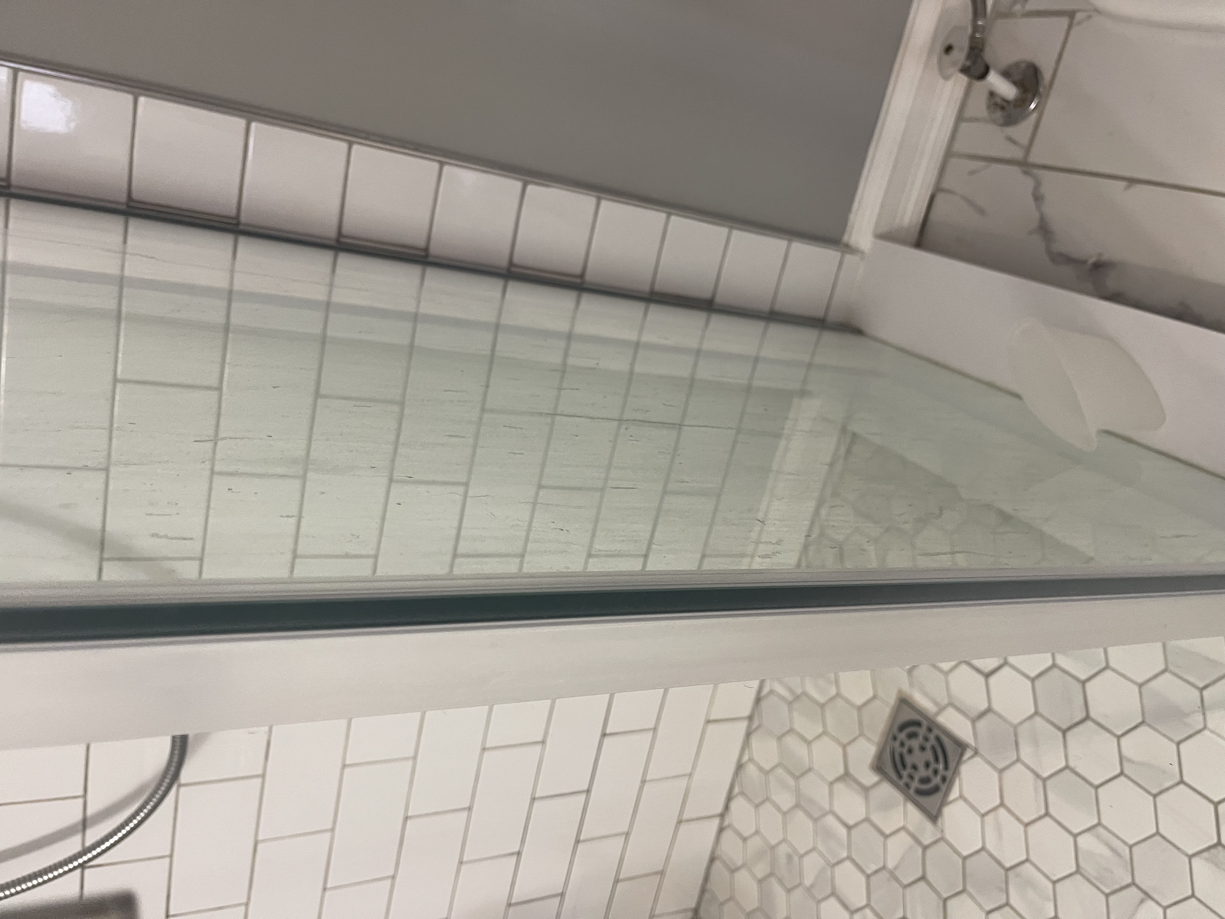 Glass shower door wirh soap scum and heavy build up. Bar soaps are very harsh on glass and create a hard coating that is difficult to remove.