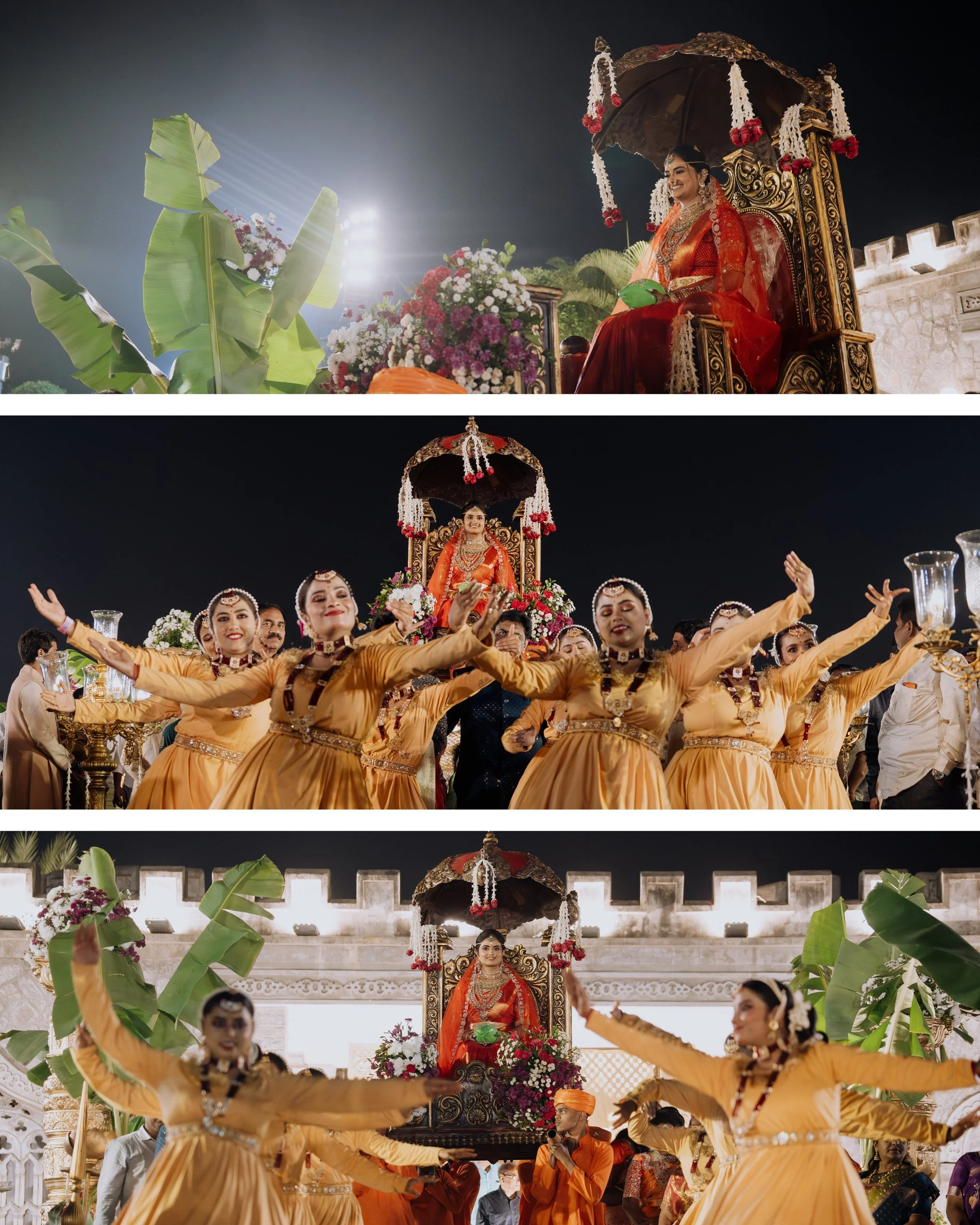 A bride in traditional Indian attire seated on a decorated chariot during a night wedding celebration, surrounded by dancers in yellow costumes performing a dance.