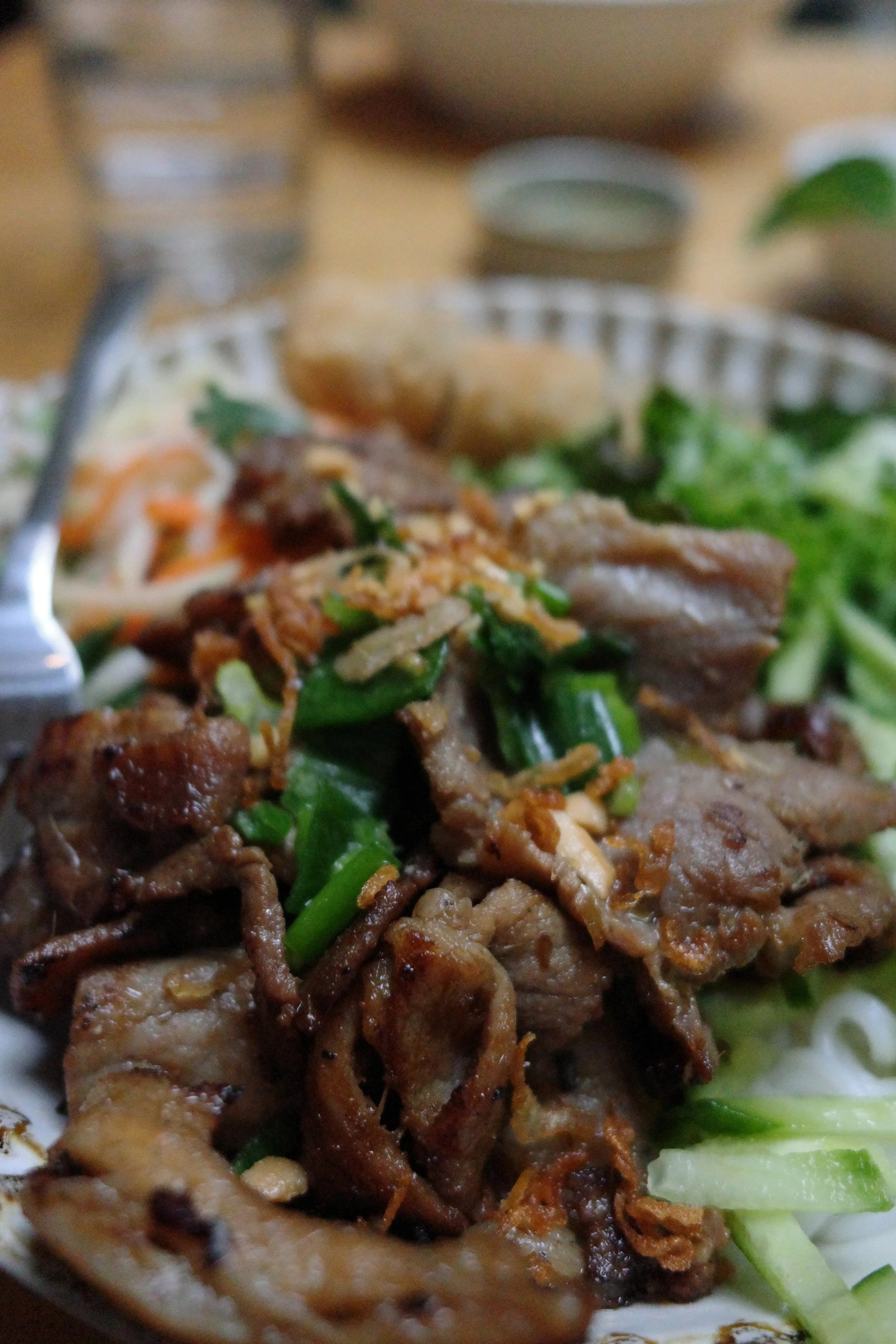 Close-up of a plate of stir-fried meat with green vegetables.