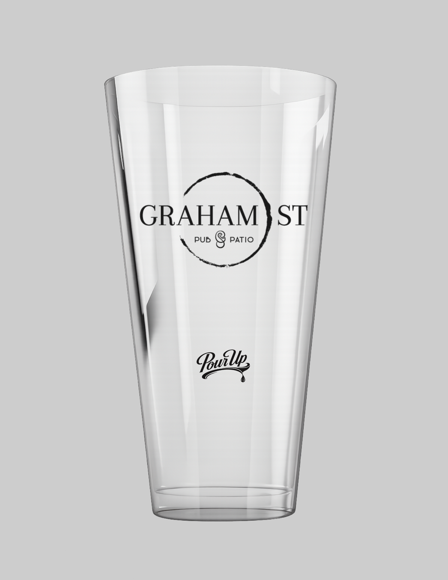 A transparent, empty pint glass with a logo that reads 'Graham St Pub & Patio' in black text, and a circular black brushstroke encircling the text, set against a light gray background.