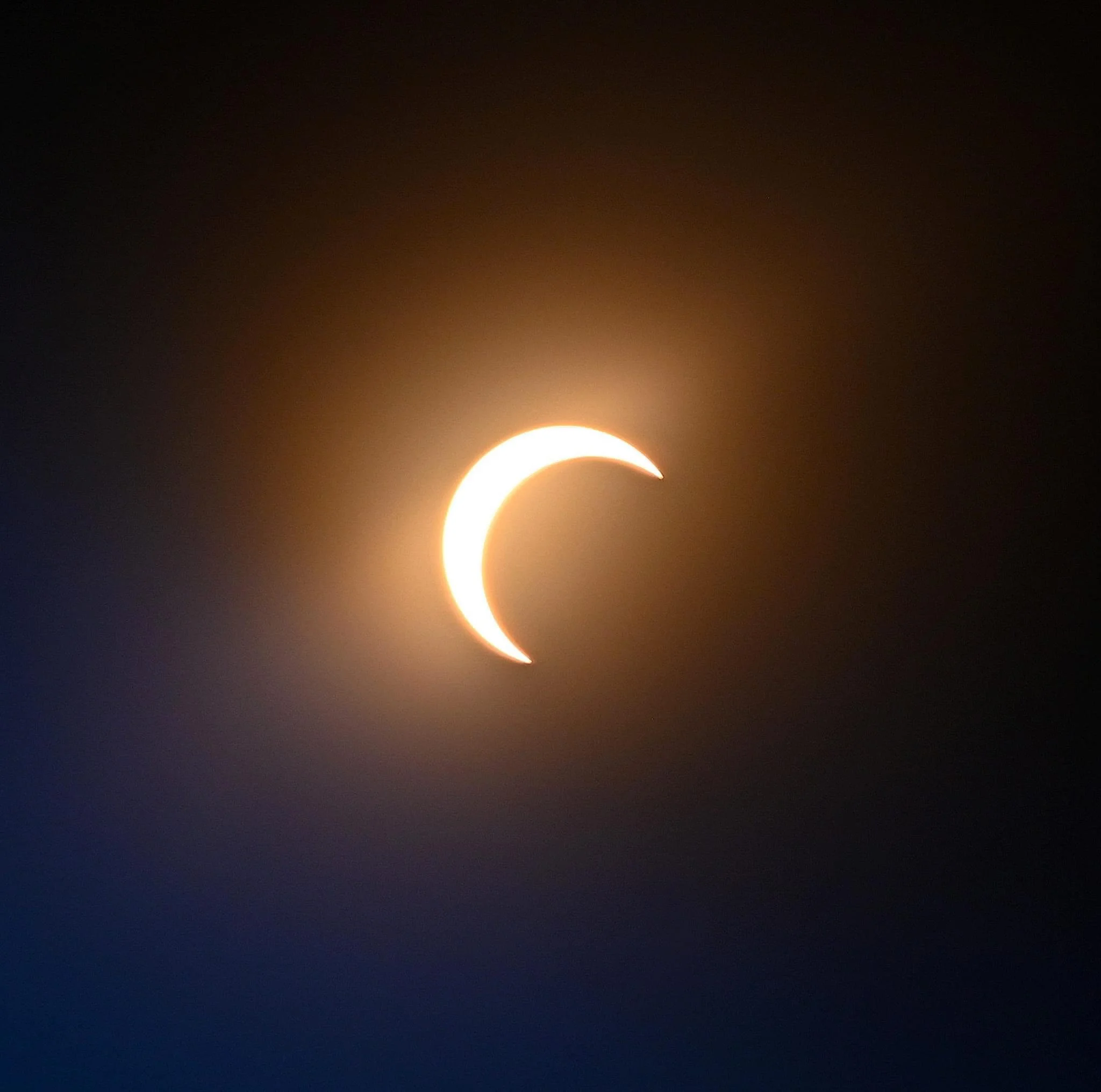 Crescent moon in the night sky with a bright sun or star close to the bottom of the image.