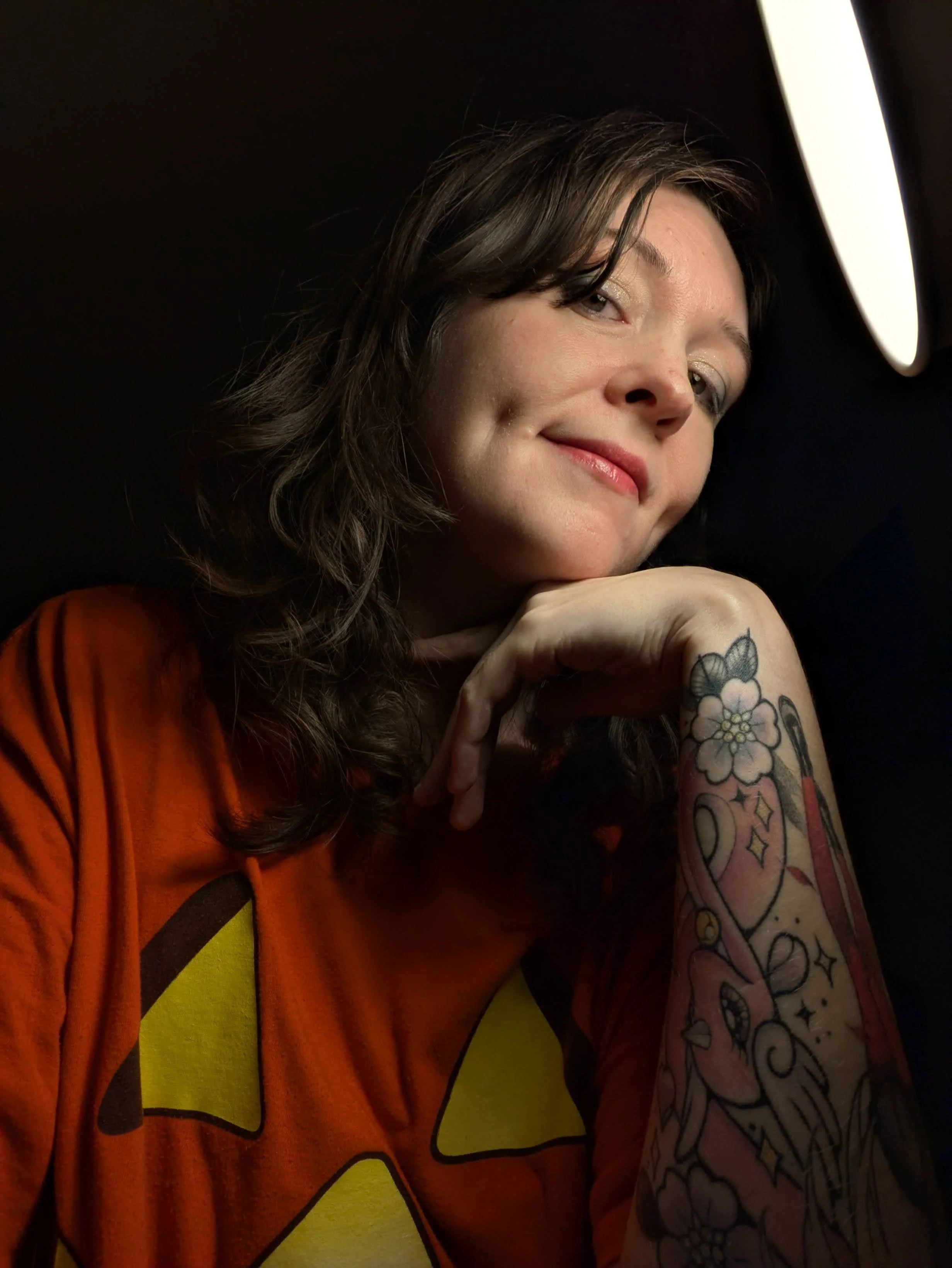 picture of the artist/author Katerina Dicker, wearing a jack-o-lantern shirt