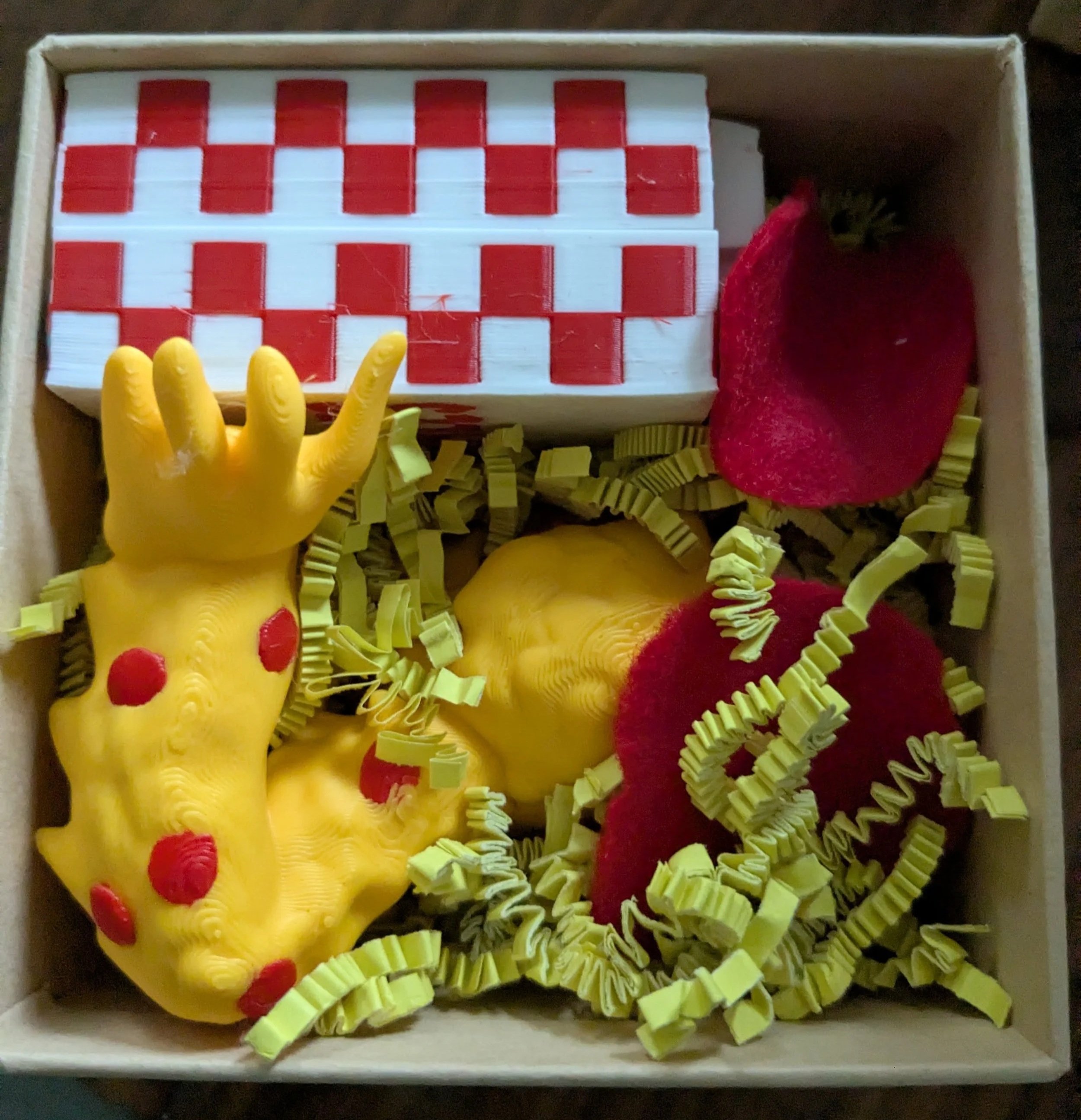 pizza monster and box nestled in a box with crinkled cheese paper and felt red pepperonis