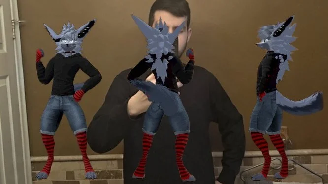 A person standing in front of a mirror taking a selfie with three anthropomorphic wolf figures with pixelated, cartoonish appearances, wearing black sweaters, denim shorts, and red and black striped socks.