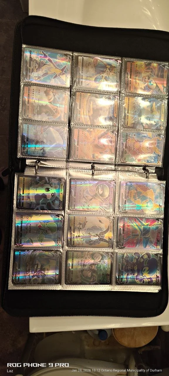 A black card binder holding multiple holographic Pokémon cards.