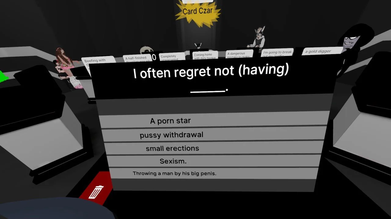 A virtual room with animated characters and a large black and gray card game screen displaying options about regret, including 'A porn star,' 'pussy withdrawal,' 'small erections,' and 'Sexism,' with a subtitle 'Throwing a man by his big penis.'