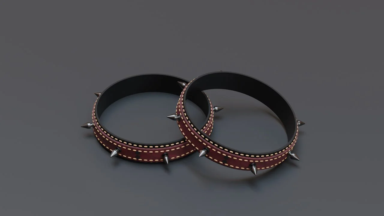Two black leather wristbands with red edges and gold stitched designs, adorned with silver spikes around the edges.
