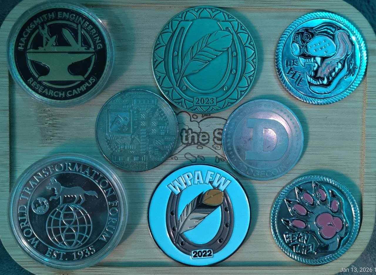 Collection of nine coins with various designs on a light wooden surface.