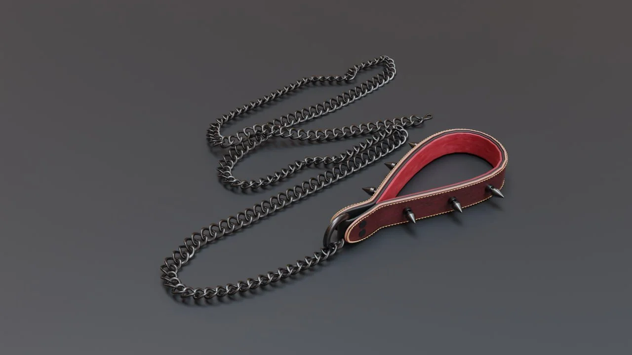 A dog collar with spikes attached to a silver chain leash on a dark surface