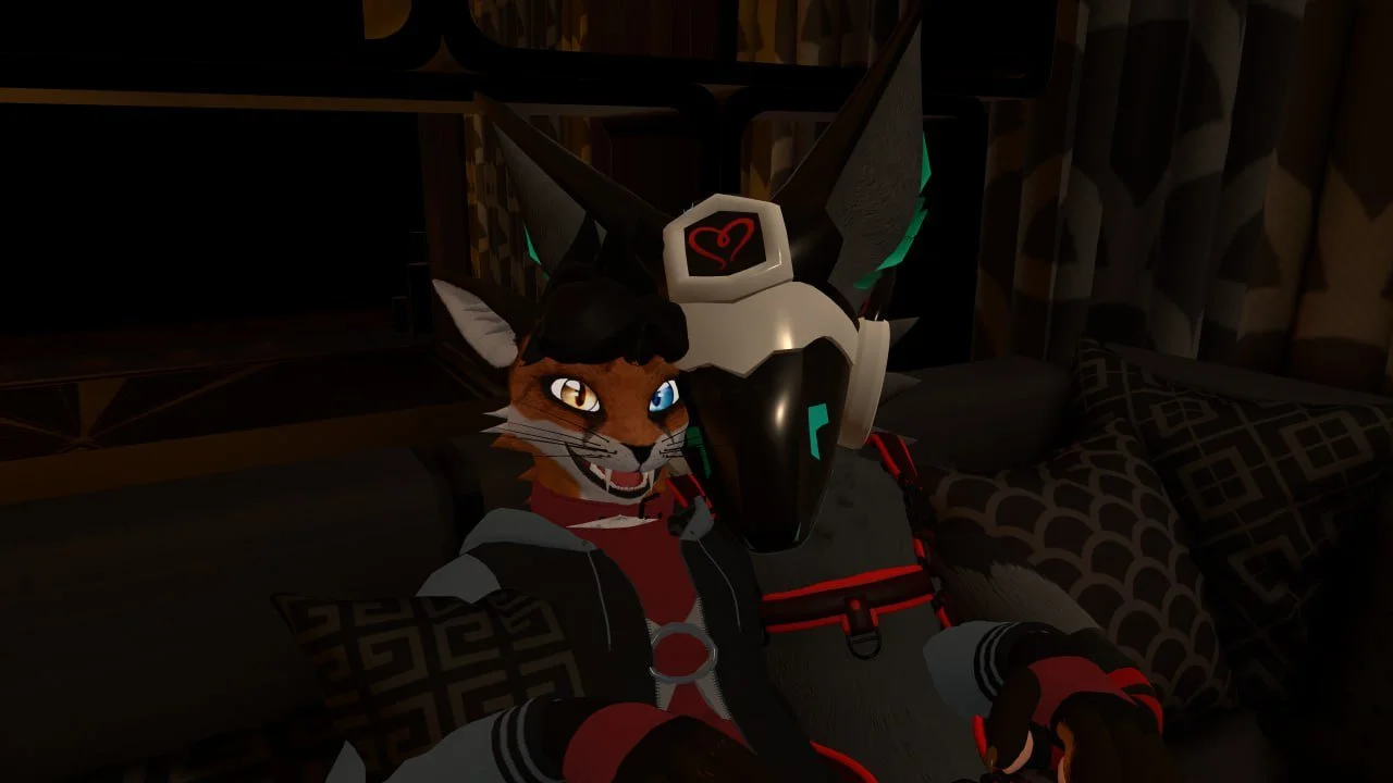 A digital illustration of a humanoid feline character with orange fur, white muzzle, and blue eyes, sitting on a bed with patterned pillows. The character is wearing a futuristic black and red outfit with a white and black robotic mask or helmet with