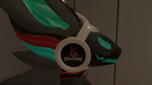 A black motorcycle helmet with teal and red wing-like designs and a stylized teal face on the front.