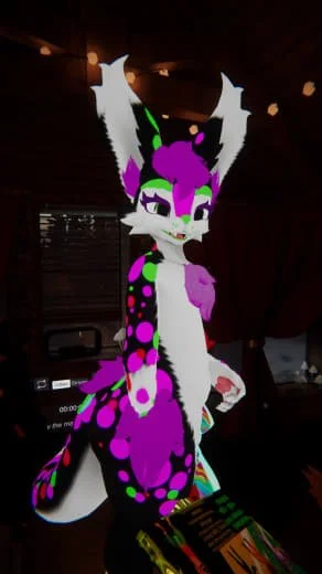 A colorful anthropomorphic fox character with large white ears, purple and green details, and a patterned tail sitting on a table in a room with wooden walls.