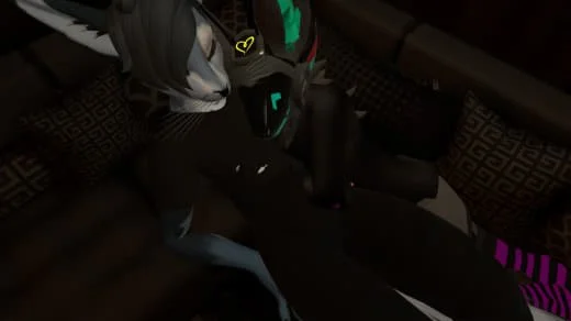 A person with headphones and dark clothing sitting on a dark-colored couch, holding a gaming controller.