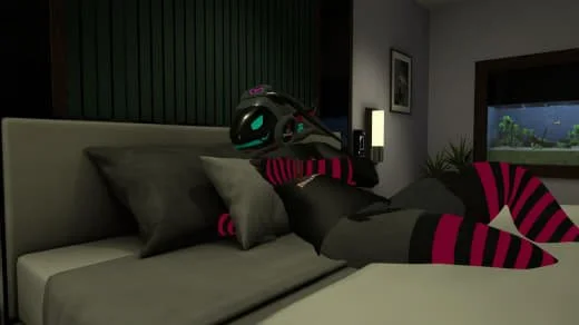 A person in a black hoodie with pink and black striped socks lying on a bed using a virtual reality headset.