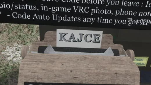 Close-up of a wooden stand with a paper sign displaying the name 'KAJCE' in black letters.