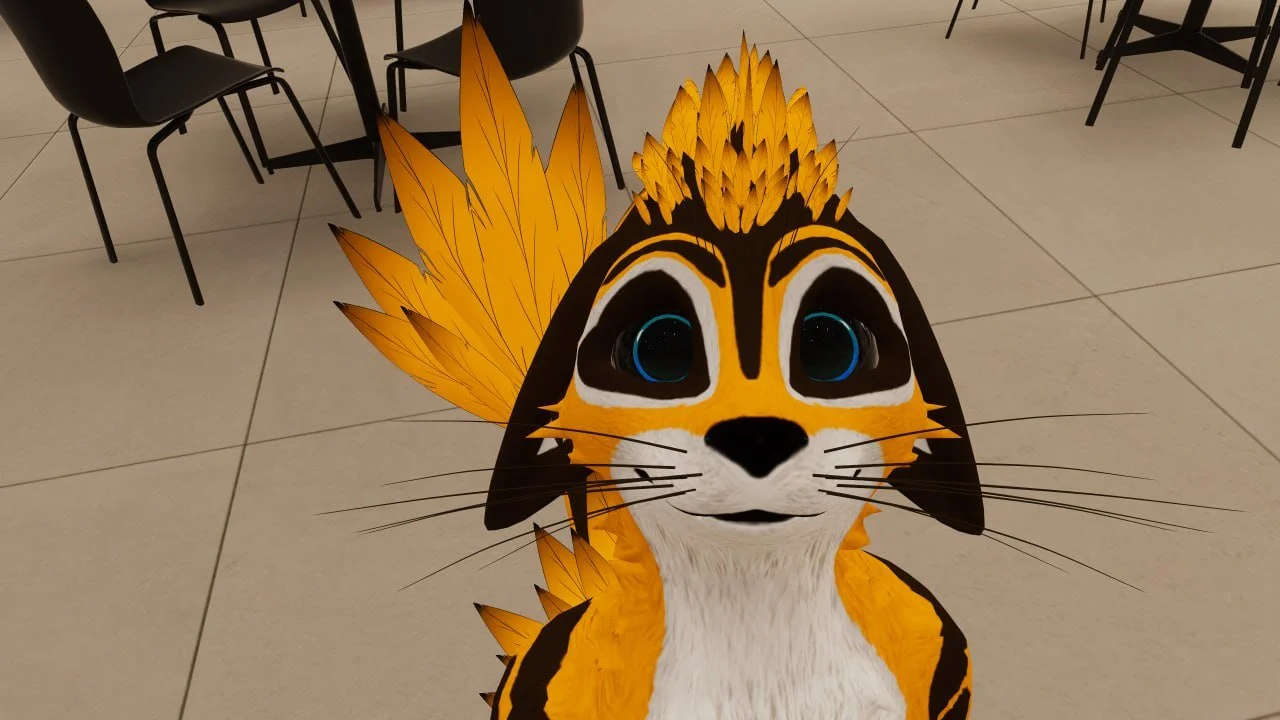 Animated mascot of a stylized orange and black cat with large blue eyes, black whiskers, and a tail that resembles yellow feathers, standing on a tiled floor with chairs in the background.