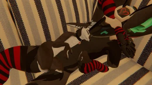 A black plush dragon toy with white, red, and teal accents, resting on a striped fabric surface.