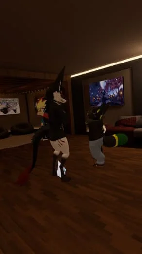 Two people dressed in animal costumes dancing in a dimly lit room with a wooden floor and large TV screen.