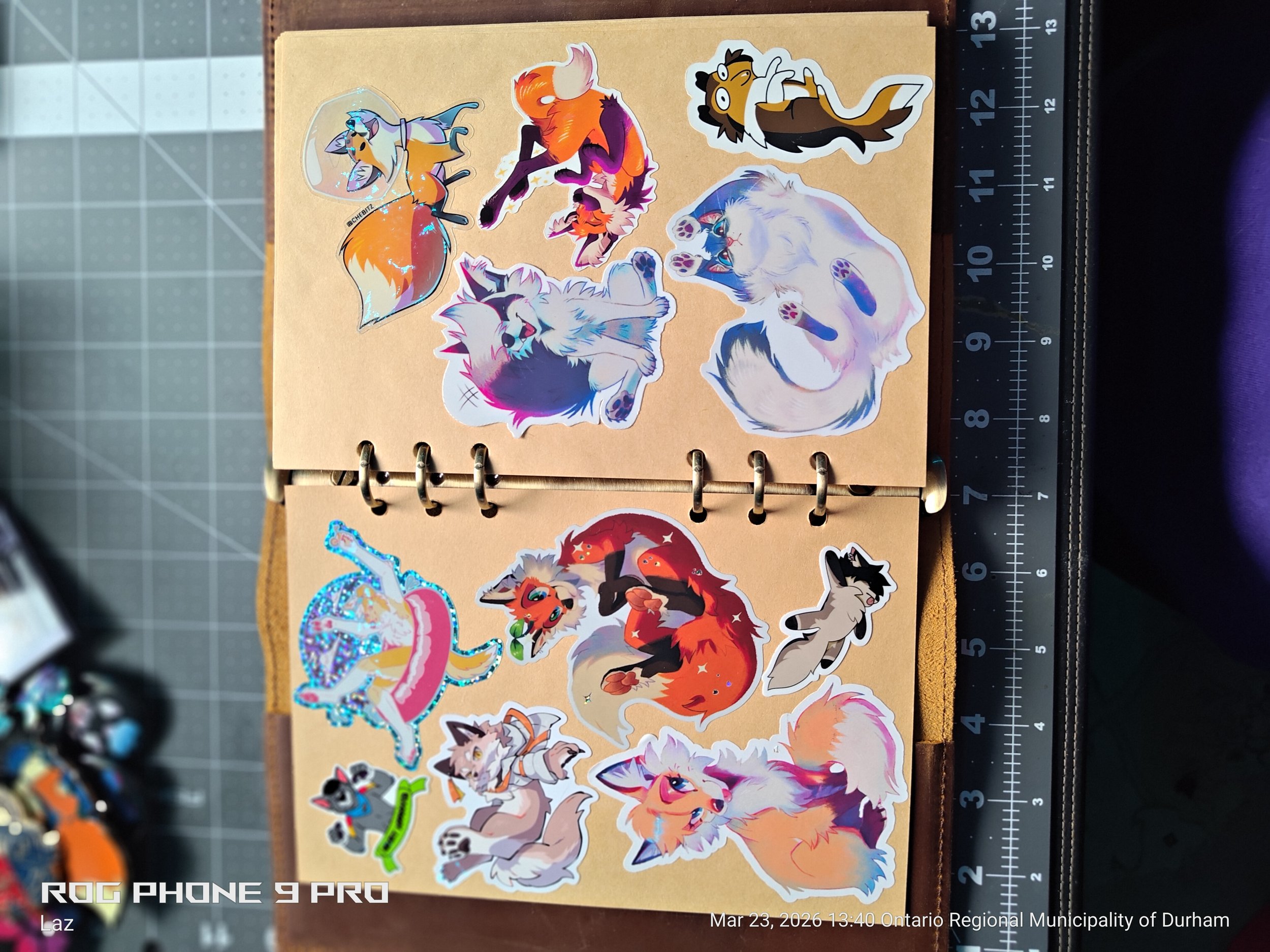Collection of animal stickers on a tan paper notebook page, including a fox, wolf, raccoon, feline, and dragon, with a ruler along the right edge.