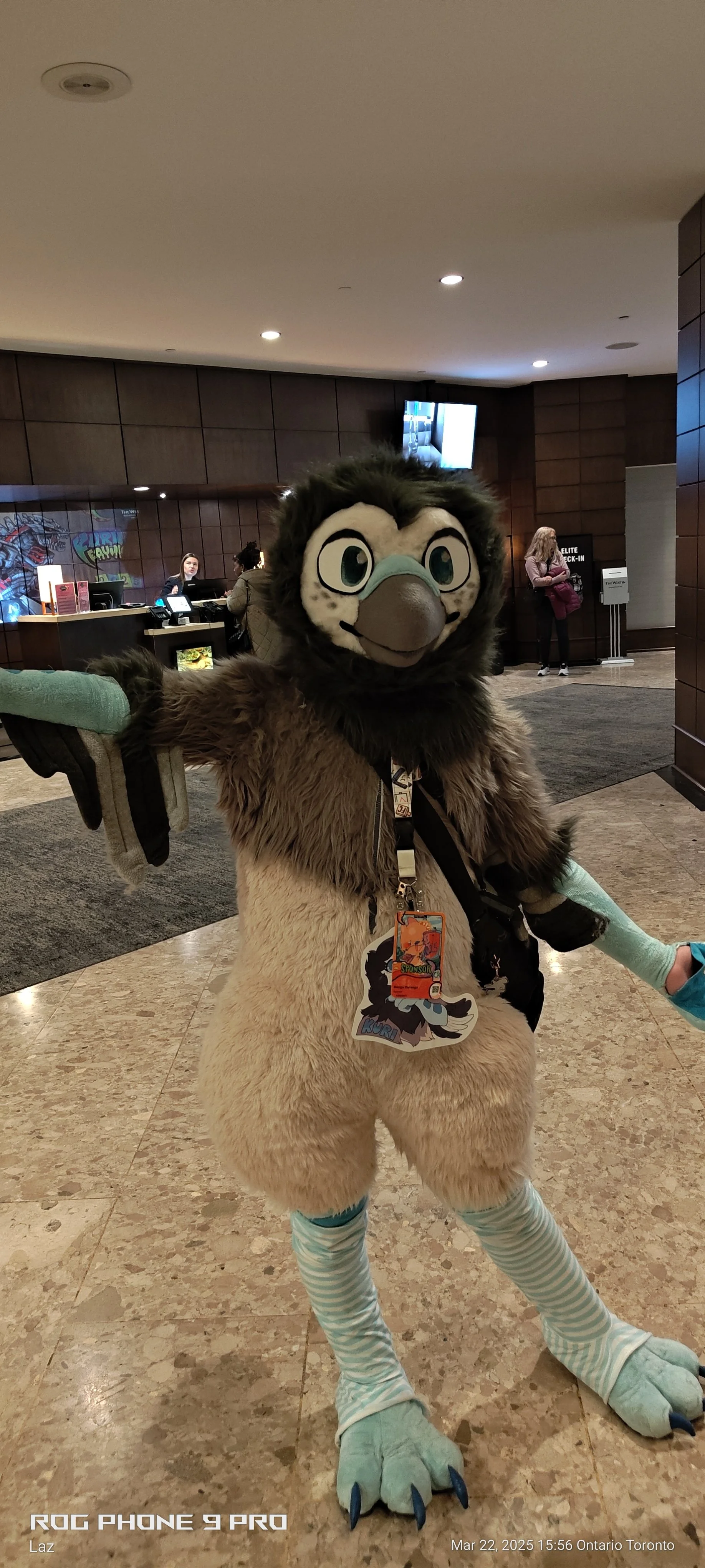 Person in a furry costume with a lion design, standing in a hotel lobby.
