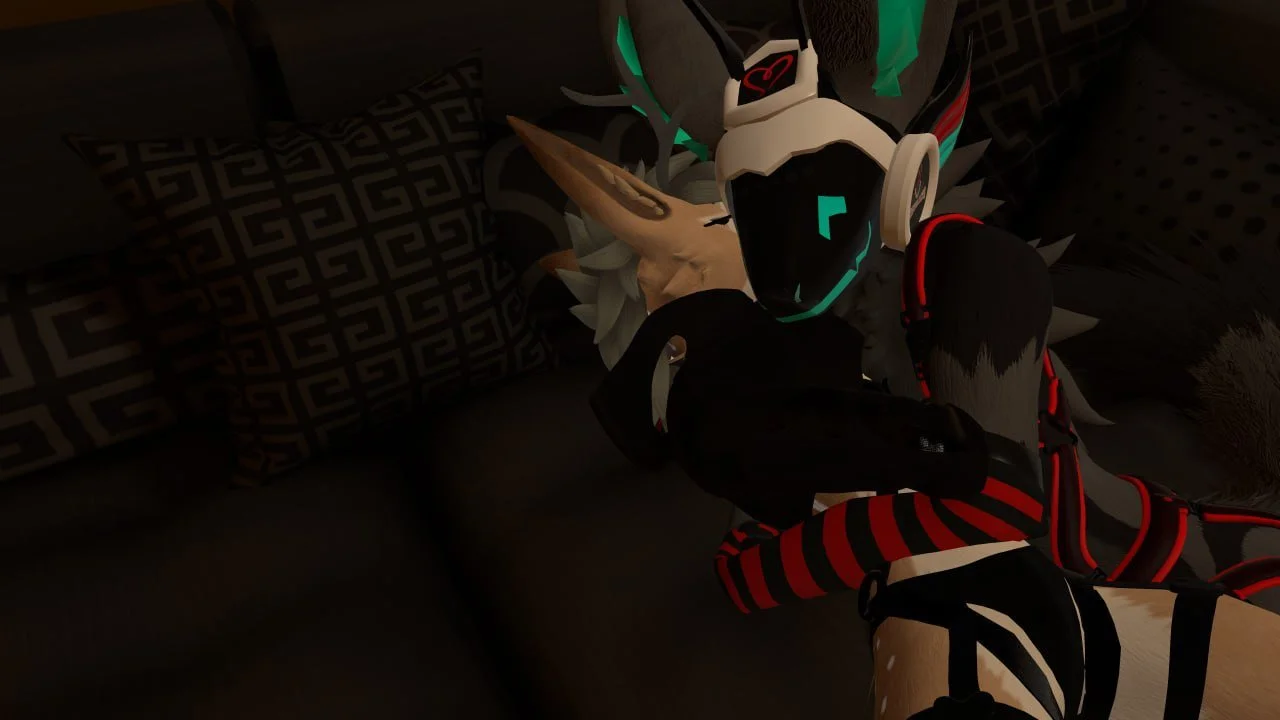 A person with dark hair and striped red and black sleeves lying on a bed, wearing a headset and a helmet, with a creature with a wolf-like face and glowing green accents beside them.