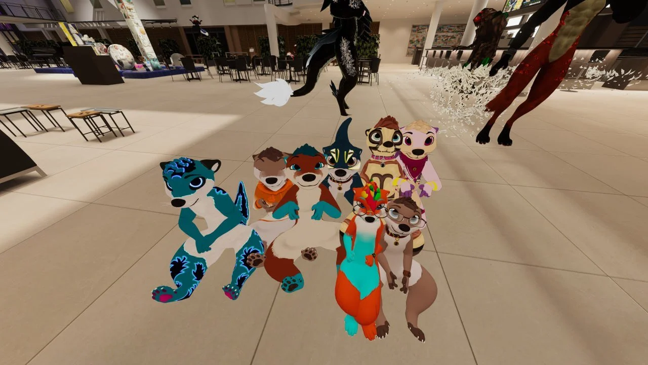 A group of virtual animated anthropomorphic animals posing together in a shopping mall or similar indoor space. The characters include a blue and white wolf, an orange fox, a darker wolf, a dark blue wolf, a leopard, a red fox, and a light yellow dog