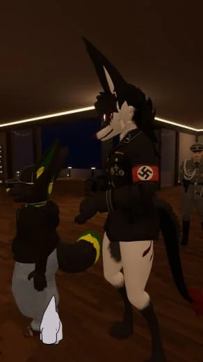 Two individuals dressed in anthropomorphic animal costumes with military and swastika armbands, standing indoors in a dimly lit room.
